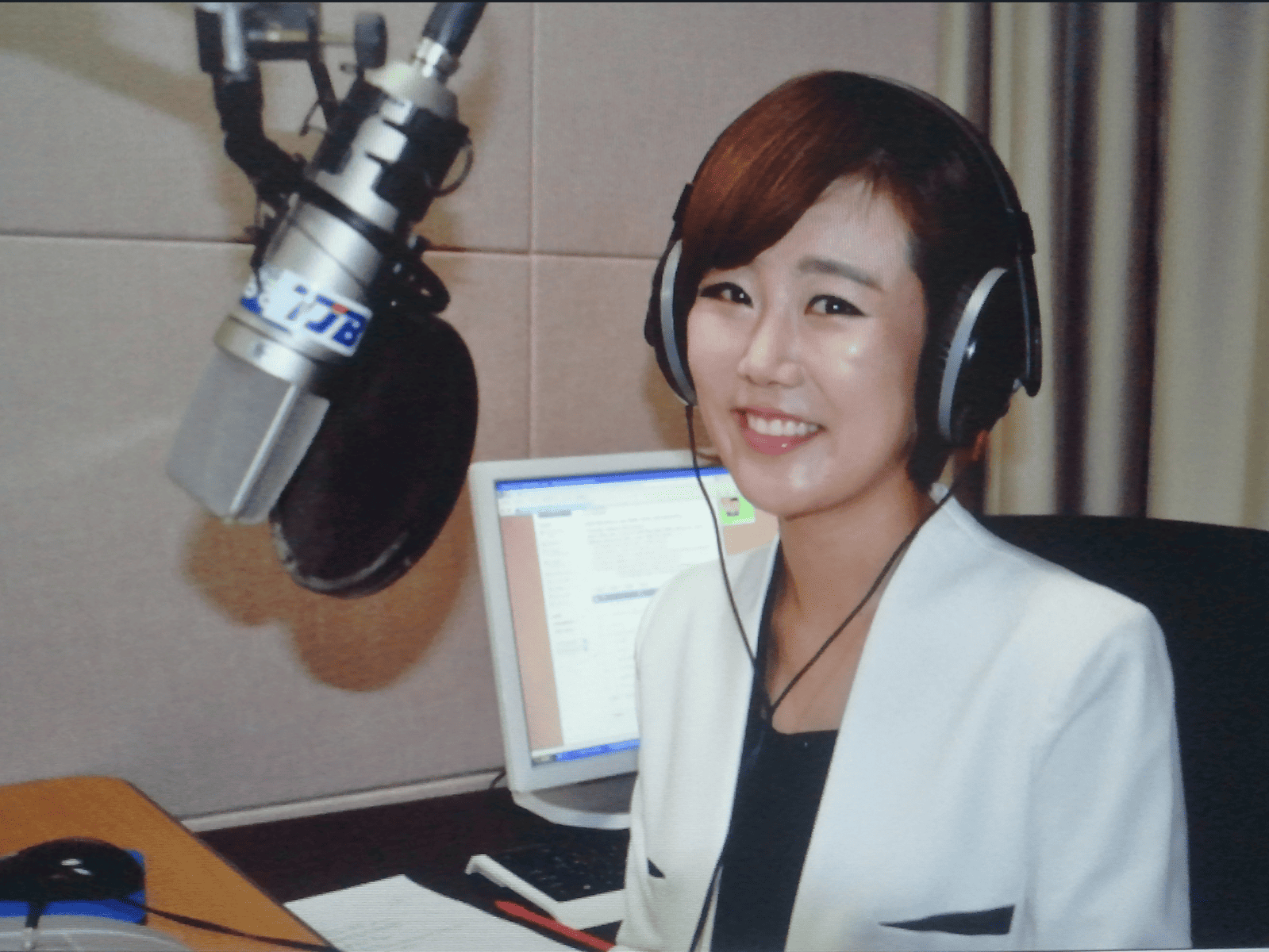 라디오 부스에서 마이크 앞에 앉아 있는 아나운서 시절 김도희 변호사